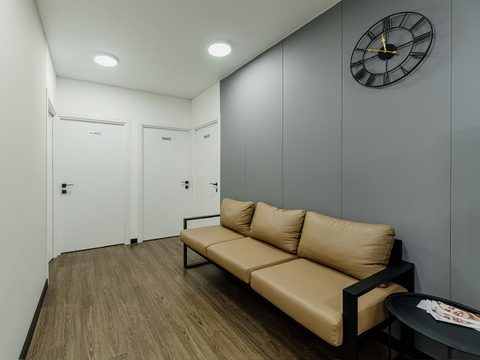 Waiting area at ESTHEMAX: a sofa beside the doors of the treatment rooms